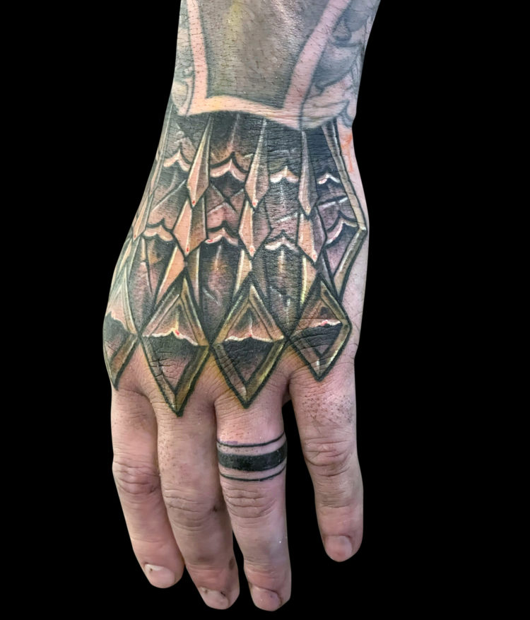 black and grey tattoo of metal armour tattoo on hand