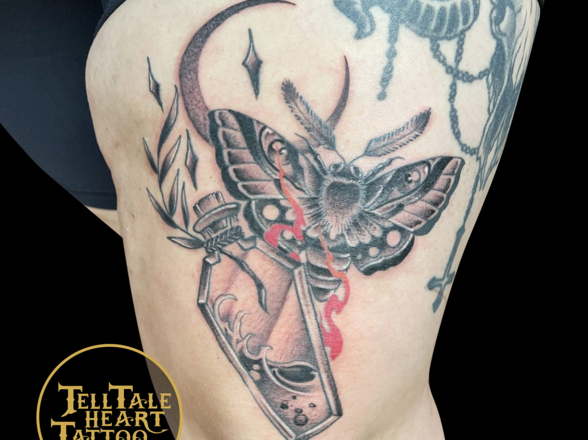 Black and grey tattoo of moth and potion bottle with crescent moon behind and red flame highlights