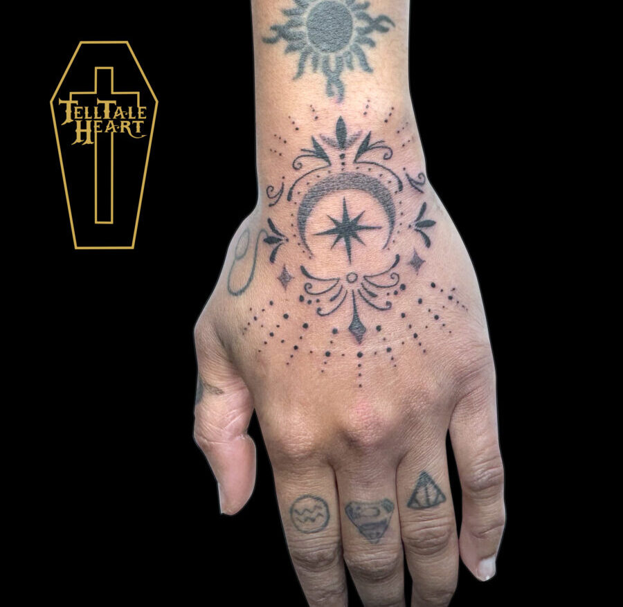 dotwork tattoo on hand featuring a crescent moon, stars, filigree and dots